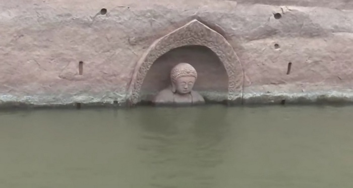 An ancient Buddha statue suddenly appeared from the water.