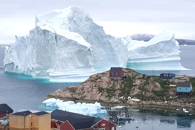 Giant iceberg overhanging a village in Greenland