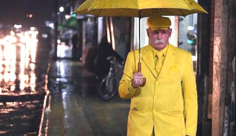 For a strange reason, a man wears only yellow clothes.