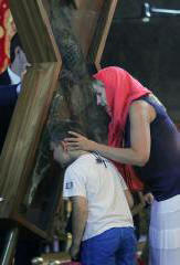 Believers breaking through to the cross of St. Andrew the First-Called kiss the shrine and hope for a miracle. Photo
