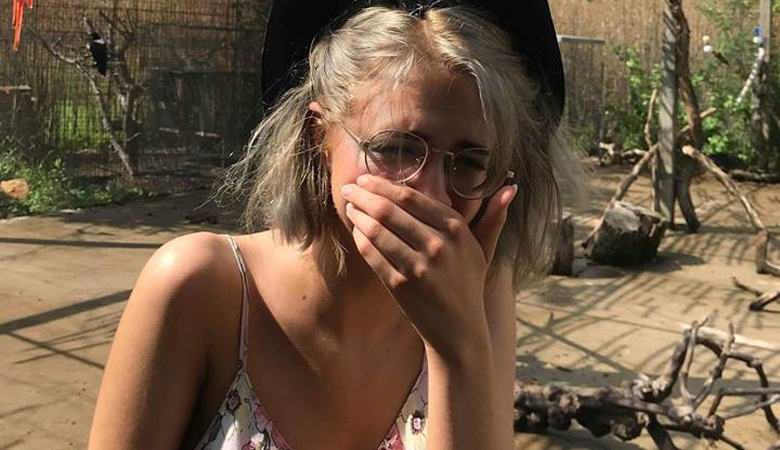 A mourning cockatoo sat on a woman’s head