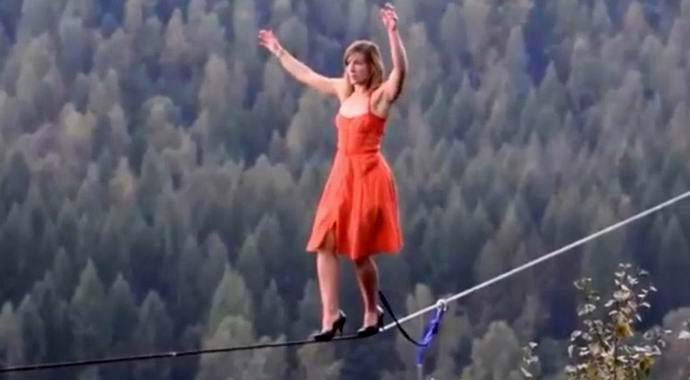 A woman tightrope walker walked over the abyss in heels